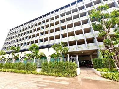 a large white building with trees in front of it at The Legendary Bang Tao 2-bedrooms apart #402 in Bang Tao Beach