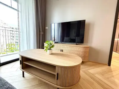 a living room with a table and a flat screen tv at The Legendary Bang Tao 2-bedrooms apart #402 in Bang Tao Beach