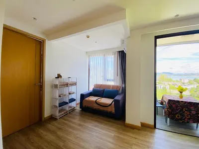 a living room with a couch and a window at Aristo 2 Condo with a sea view in Surin Beach