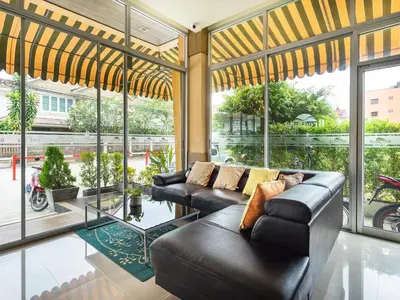 a living room with black leather furniture and large windows at Breezotel - SHA Certified in Patong Beach