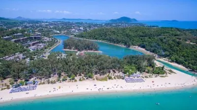 an aerial view of a beach with people on it at The Lago Nai Harn 2 BR-Walk to beach by ALL HOMES in Rawai Beach
