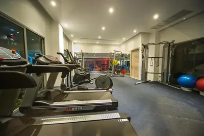 a gym with treadmills and machines in a room at The View Phuket By RESAVA in Kata Beach