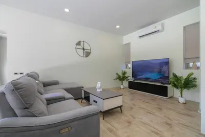 a living room with a couch and a flat screen tv at Villa Orion at Orbita Villas Rawai in Rawai Beach