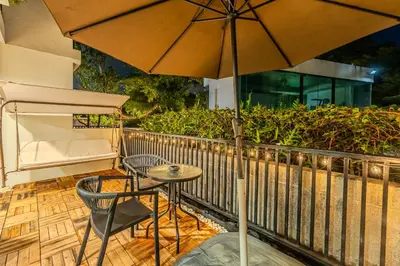 a patio with an umbrella and a table and chairs at Zcape 1 By SilqStay in Ban Thalat Choeng Thale