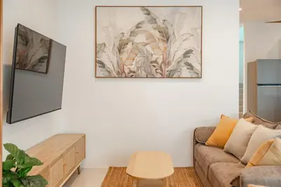 a living room with a couch and a painting on the wall at Nai Harn Beach Holiday Home - Rawai in Rawai Beach