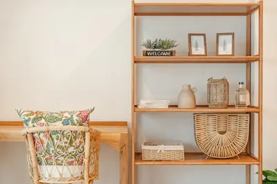a book shelf with a chair and a pillow at Nai Harn Beach Holiday Home - Rawai in Rawai Beach