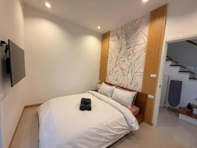 a bedroom with a bed with a black bag on it at Goldena Residence Pool Villas in Kamala Beach
