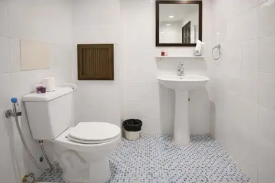 a white bathroom with a toilet and a sink at Hill Side Patong in Patong Beach