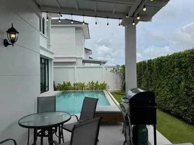 a patio with a table and chairs next to a swimming pool at Вилла на Бангтао in Ban Thalat Choeng Thale