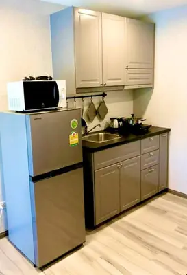 a small kitchen with a refrigerator and a sink at naiyang beach in Phuket