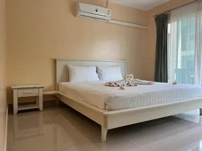 a bedroom with a large bed with a window at Kata beach at pool house in Kata Beach