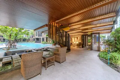 an outdoor patio with a pool and a wooden ceiling at 1BR Designer Mountain View Condo - Central Phuket in Phuket Town