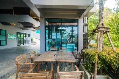 a wooden table and chairs in front of a building at Private apartment at Emerald Terrace by Lofty in Patong Beach