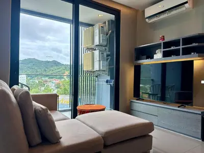 a living room with a couch and a large window at Room in Kamala at Citygate Condo in Kamala Beach