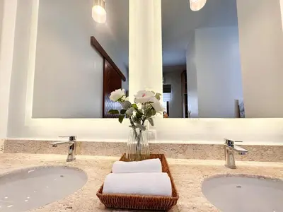 a bathroom with two sinks and a vase of flowers at La Nissta Villa 4bdr pool Villa Phuket in Koh Lone