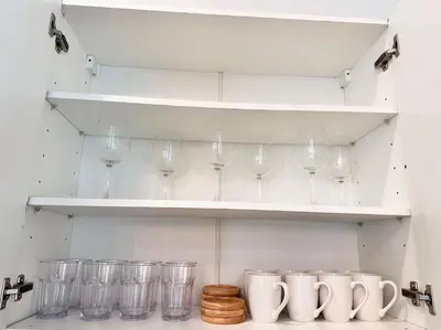 a row of wine glasses on shelves in a kitchen at La Nissta Villa 4bdr pool Villa Phuket in Koh Lone
