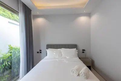 a bedroom with a white bed and a window at Botanica Foresta x MonthStayZ Thailand in Bang Tao Beach