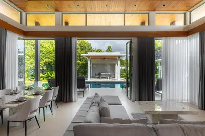 a living room with a couch and tables and a pool at Botanica Foresta x MonthStayZ Thailand in Bang Tao Beach