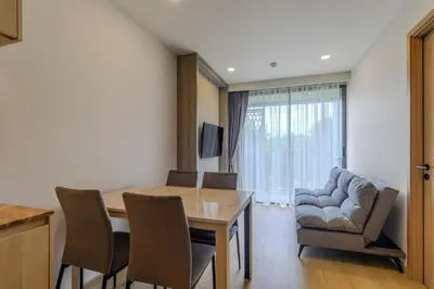 a living room with a table and chairs and a couch at C240 New Prime Location 1BR Condo Near Beach Club in Thalang