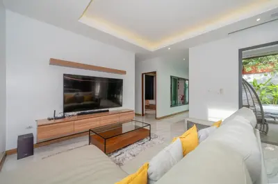 a living room with a white couch and a flat screen tv at Nicky Villa Luxury Private Haven in BangTao Laguna in Laguna Phuket