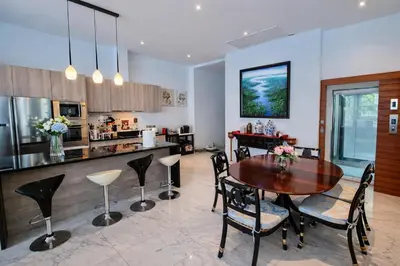 a kitchen with a table and chairs and a counter at Luxury Villa with Panoramic Seaview, Private Pool in Ban Saiyuan (1)