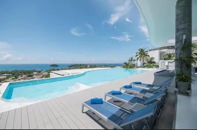 a swimming pool with lounge chairs and the ocean at Luxury Penthouse with Private Pool at View Phuket F9 in Karon Beach