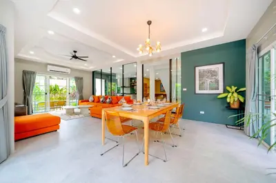 a dining room with a table and orange chairs at Exclusive & Private! Elegant Two-Storey Pool Villa Anong in Kamala in Kamala Beach