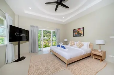 a bedroom with a bed and a flat screen tv at Exclusive & Private! Elegant Two-Storey Pool Villa Anong in Kamala in Kamala Beach