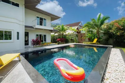 a swimming pool with a red and yellow raft in front of a house at Exclusive & Private! Elegant Two-Storey Pool Villa Anong in Kamala in Kamala Beach