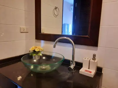 a bathroom sink with a green bowl in it at Purimas Resortel in Rawai Beach