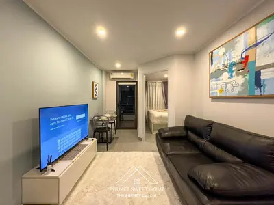 a living room with a couch and a flat screen tv at Condo for rent chalong Rawai 610 in Ban Klang