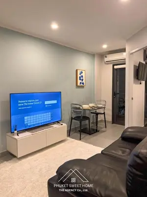 a living room with a flat screen tv and a table at Condo for rent chalong Rawai 610 in Ban Klang