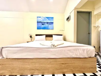 a bedroom with a large bed with a large white bedspread at Vista Inn Patong in Patong Beach