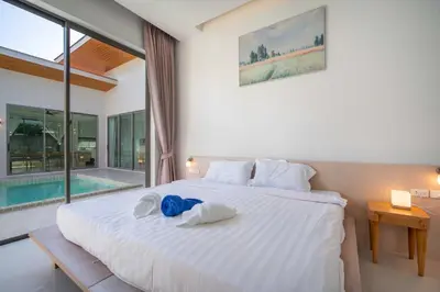 a bedroom with a large bed with towels on it at Elm pool villa Phuket in Kata Beach