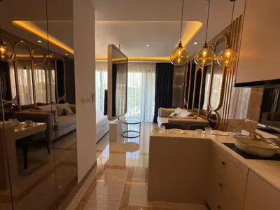 a kitchen with a living room and a dining room at Новая студия Bellevue Bangtao in Laguna Phuket