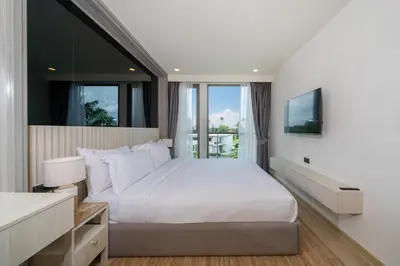 a bedroom with a large white bed and a window at Ozone Condominium BangTao Laguna Area in Phuket