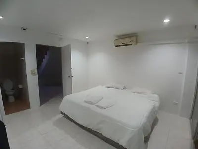 a white bedroom with a bed in a room at Didim Guest House Patong in Patong Beach