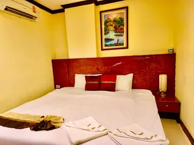 a bedroom with a bed with white sheets and red pillows at Hotel Hollywood Inn Love Patong in Patong Beach