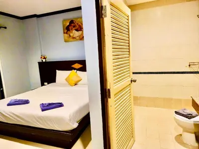 a bedroom with a bed and a bathroom with a toilet at Hotel Hollywood Inn Love Patong in Patong Beach