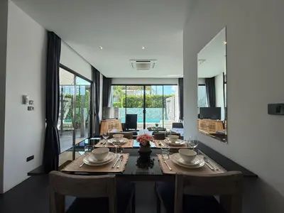 a dining room with a table and a large mirror at 2 Bedroom Pool Villa Chalong in Chalong