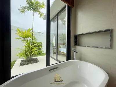 a white bath tub in a bathroom with a window at 4 Br Pool Villa in Chalong in Phuket Town
