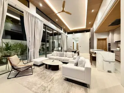 a living room with white furniture and a kitchen at 4 Br Pool Villa in Chalong in Phuket Town