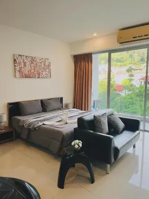 a bedroom with a bed and a couch and a window at CHIC Beautiful apartment by the seaside, terrace, pool, free gym in Karon Beach