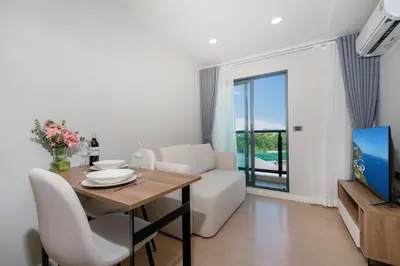a living room with a dining table and a tv at Brand new 1 BR apt 403 at Space Condo near Boat Avenue in Bang Tao Beach