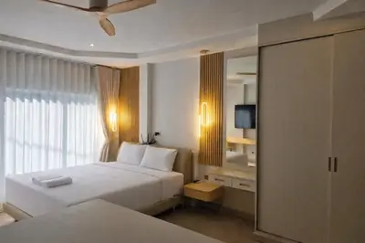 a hotel room with two beds and a mirror at The Escape Kamala in Kamala Beach