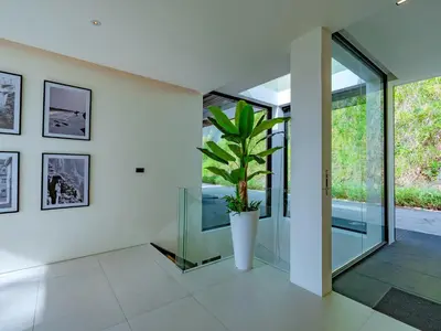 a pivot door in a house with a potted plant at NEW Luxury 4BR Villa in Layan - Villa Zuma in Layan Beach
