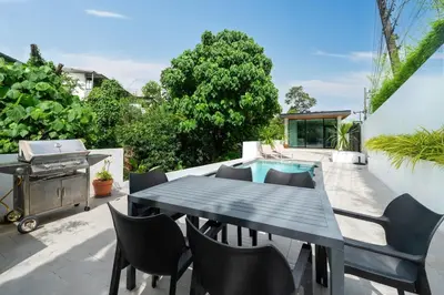 a patio with a table and chairs and a grill at Villa Heaven in Kata Beach