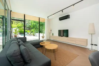 a living room with a couch and a tv at Villa Heaven in Kata Beach