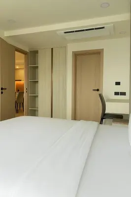 a bedroom with a white bed and a chair at The Ozone Condominium 2 bedroom by Search Estate in Phuket Town