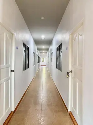 an empty hallway with white walls and doors at Cozy Bay Rawai in Phuket Town